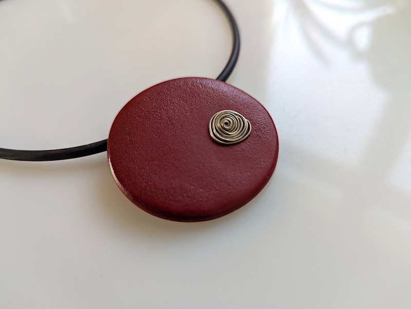 Keramikkette warmes rot  rund mit versilberter Spirale